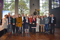 Foto: Gruppe von Personen steht gemeinsam in einer Halle.