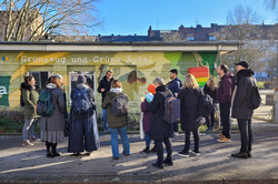 Mehrere Personen stehen im Freien vor einem  Gebäude