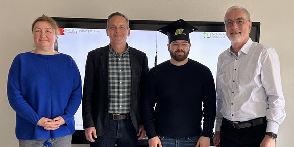Foto: Vier Personen stehen in einer Gruppe.
