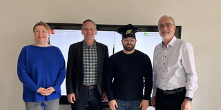 Foto: Vier Personen stehen in einer Gruppe.