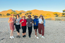 Gruppenbild: 5 Personen stehen in einer Reihe. Sie halten Getränke in der Hand.