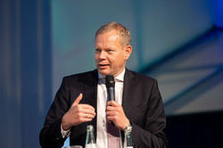 Unternehmensvertreter Johannes Pöttering bei der Podiumsdiskussion der Akademie „Die Wolfsburg“ mit Mikrofon in der Hand