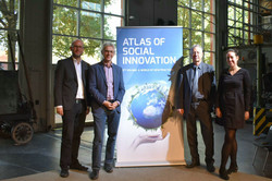 Foto: Christoph Kaletka, Jürgen Howaldt, Antonius Schröder und Marthe Zirngiebl stehen neben einem Roll-up mit dem Cover des Atlas of Social Innovation