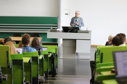 Jürgen Howaldt steht in einem Hörsaal. Es sitzen viele Personen auf den Rängen vor ihm.