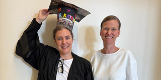 Katrin Bauer, die einen Graduiertenhut trägt