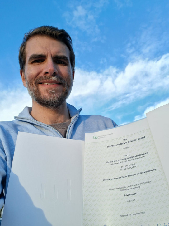 Rick Hölsgens holds his certificate into the camera.
