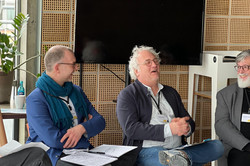 Photo: Four people are sitting in a semicircle during a panel discussion.