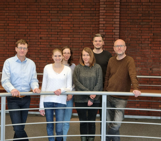 Six people stand on the gallery in the library in the social research centre