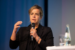 NRW-Wirtschaftsministerin Mona Neubauer NRW-Wirtschaftsministerin Mona Neubauer bei der Podiumsdiskussion mit Mikrofon in der Hand