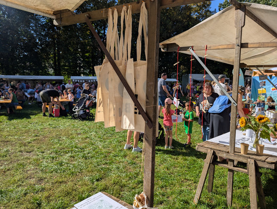 Ein Foto vom Quartiersfest, auf dem zu sehen ist, wie verschiedene Menschen die diversen Stände besuchen. 