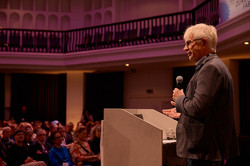 Jürgen Howaldt hält ein Mikrofon in der Hand, er steht vor einem Podium. Im Saal sitzt eine große Zuhörerschaft.