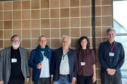 Group photo: Five people wearing ID badges around their necks.
