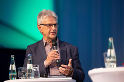 Prof. Dr. Jürgen Howaldt bei der Podiumsdiskussion der Akademie „Die Wolfsburg“ Prof. Dr. Jürgen Howaldt steht mit Mikrofon in der Hand an einem Stehtisch