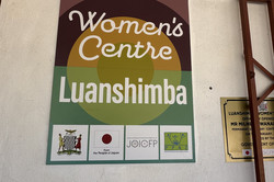 Foto: Schild mit der Aufschrift eines Frauenzentrums namens Luanshimba und Logos von unterstützenden Organisationen.