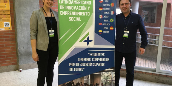 Sabrina Janz and Dmitri Domanski from the Social Research Centre Dortmund stand smiling next to a display during their stay in Bogotá as part of the "Students4Change" project.