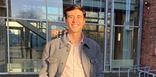 Foto: Andres Zarrate vor dem Haupteingang der sfs
