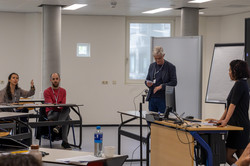 Foto: Jürgen Howaldt steht vorne in einem Seminarraum neben Pult und Flipchart; Teilnehmende sitzen an Tischen.