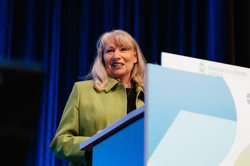 Foto: Eine Frau steht an einem Rednerpult.