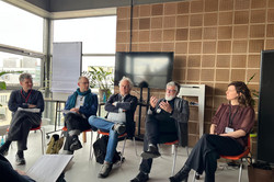 Photo: Five people are sitting in front of an audience during a panel discussion