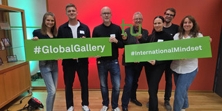 sfs researchers at the Global Gallery Photo: Seven people holding up two signs together.